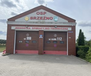 Remiza OSP Brzeźno przy ul. Głównej 70A z numerami alarmowymi 998 i 112 na bramach garażowych